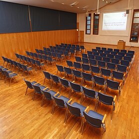 Blick auf den Marie-Antoinette-Saal. Rechts und links befinden sich Wände, der Saal ist mit blauen Stühlen gefüllt, Gäste sind nicht vorhanden. Foto: Contrast Marketing für Stadt Günzburg